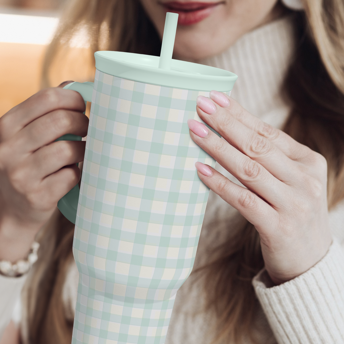 Mint gingham 40oz tumbler with straw, held in hands, front close-up