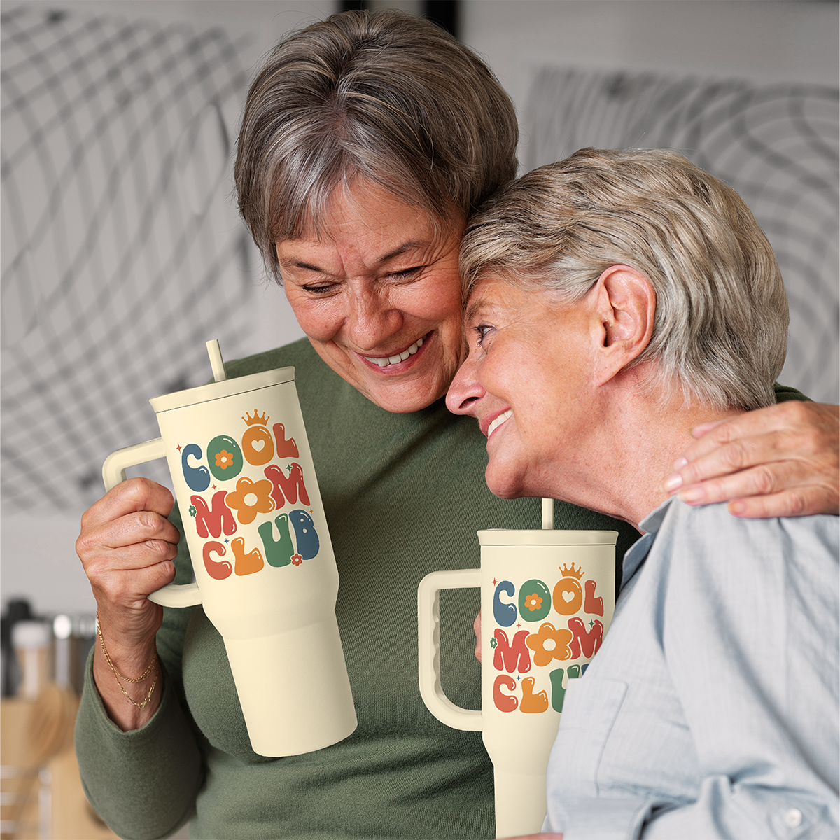 Beige 40oz slider tumbler with straw and colorful graphic, held by two people