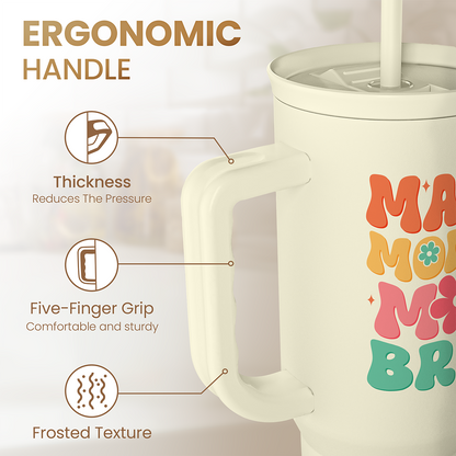 Cream tumbler with ergonomic handle and textured grip area; straw opening and “MAMA MOMMY BRUH”.