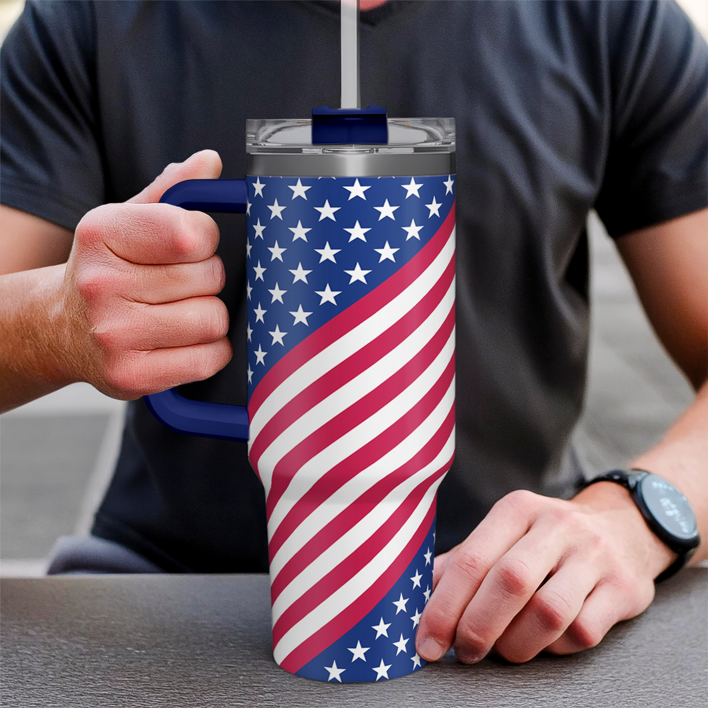 American flag 40oz tumbler with blue handle, held in hand