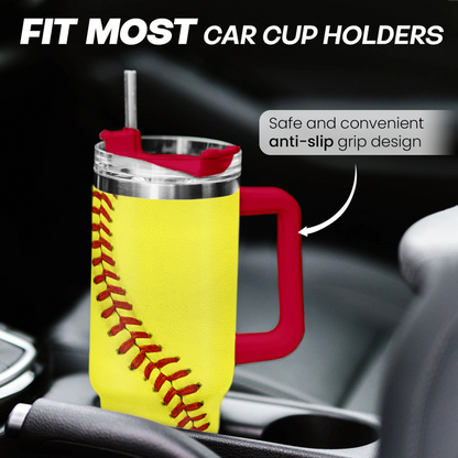 Yellow softball tumbler with red handle, clear lid, and baseball seam in car cup holder