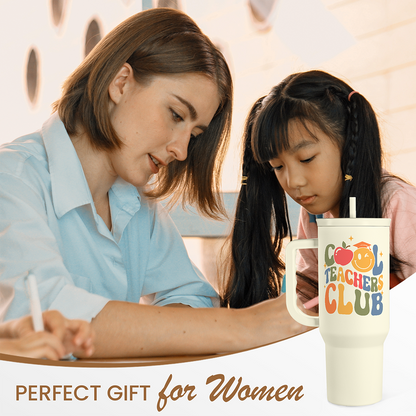 Beige Teachers Club tumbler with straw on a desk, shown upright with handle