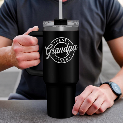 Black 40oz tumbler with handle and clear lid, "Best Grandpa Ever" logo, held by hand