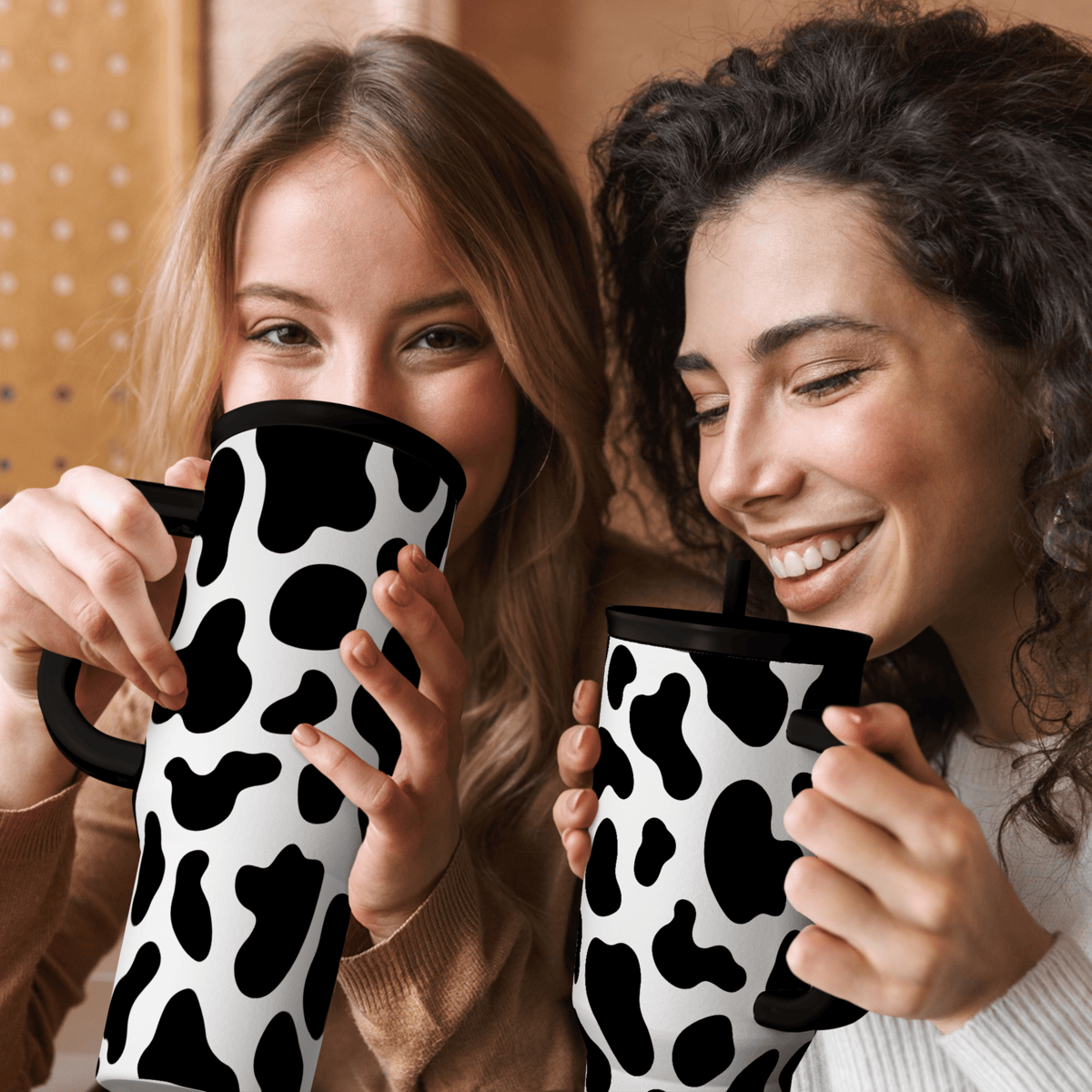 Two Slidemate cow-print 40oz tumblers with black lids and straws