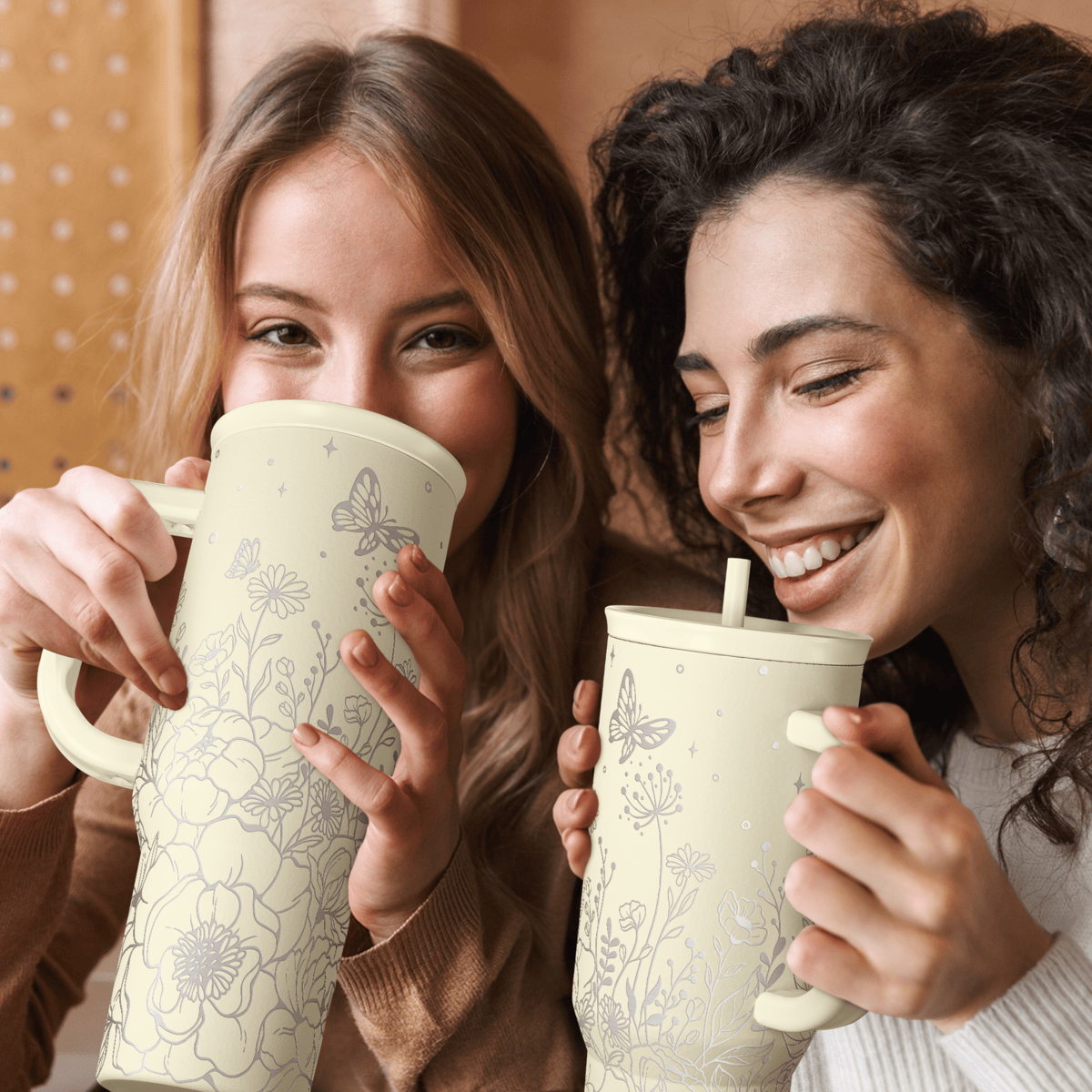 Beige floral 40oz tumbler with handle, straw slide lid, held by two people