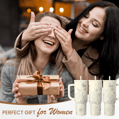 Beige floral tumblers with handles standing beside a wrapped gift