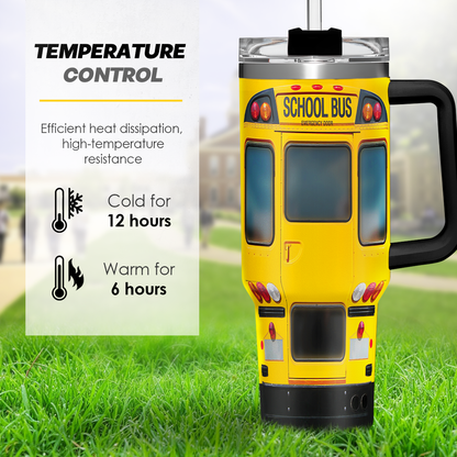Yellow school bus tumbler with black handle and clear lid standing upright