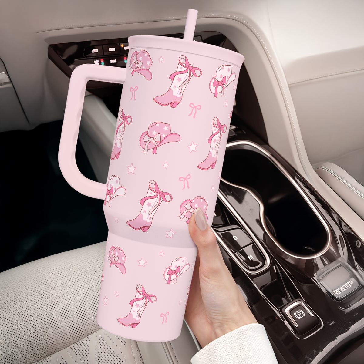 Pink 40oz tumbler with handle and straw in car cup holder, cowgirl pattern