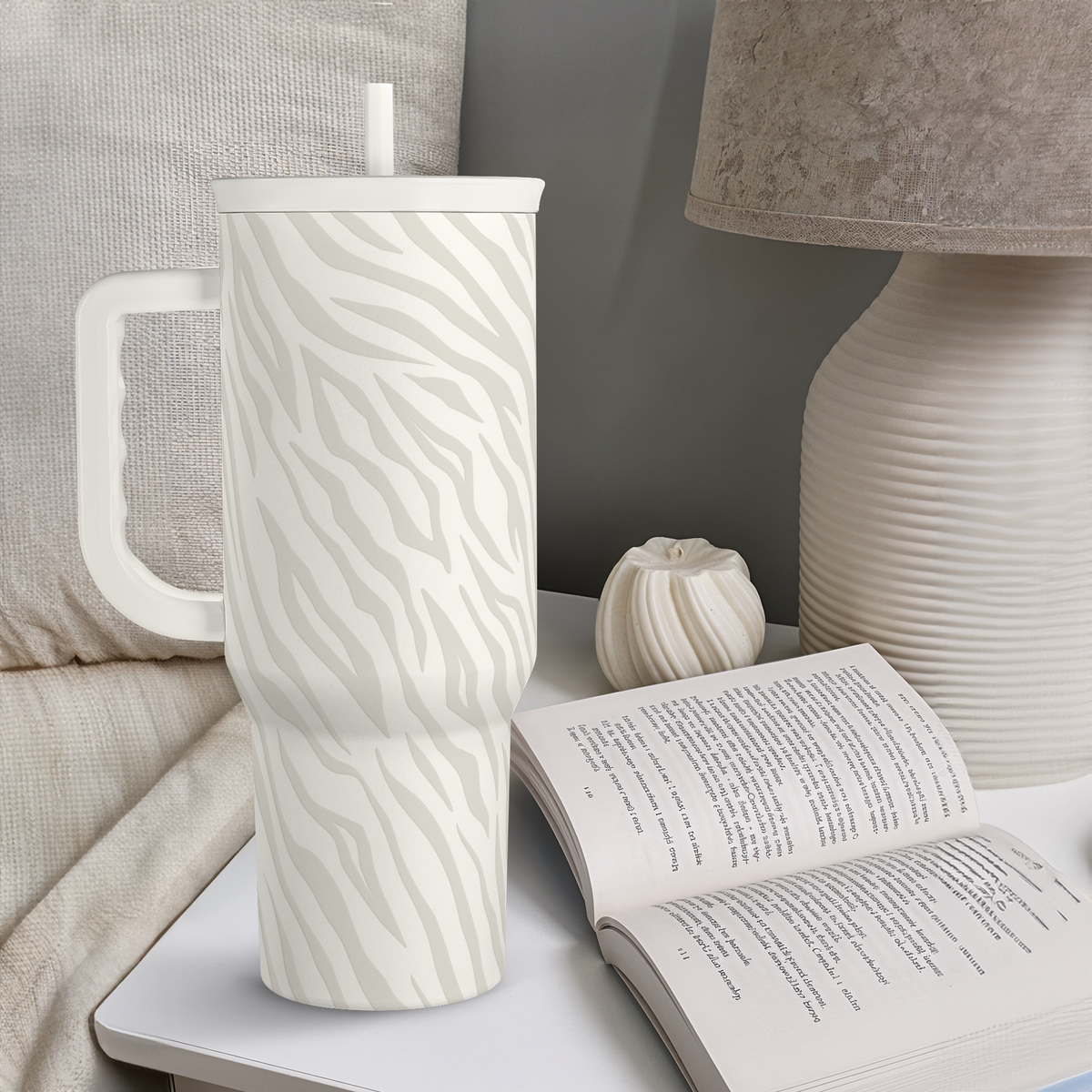 Zebra-print 40oz insulated tumbler with handle and straw on a table