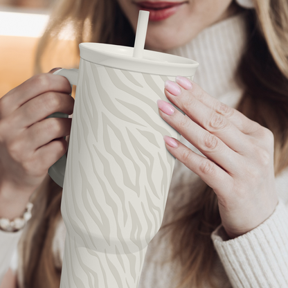 Zebra-print 40oz insulated tumbler with straw, held for drinking