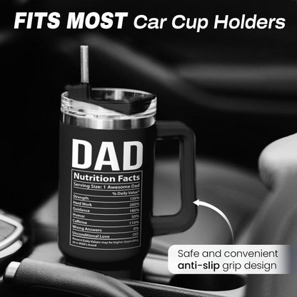 Black 40oz tumbler with handle and straw, “DAD Nutrition Facts” label, car cup holder view