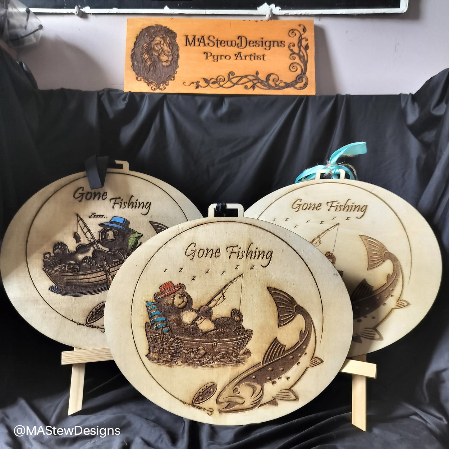 Round wood wall hangers engraved 'Gone Fishing' with fishing scenes and fish
