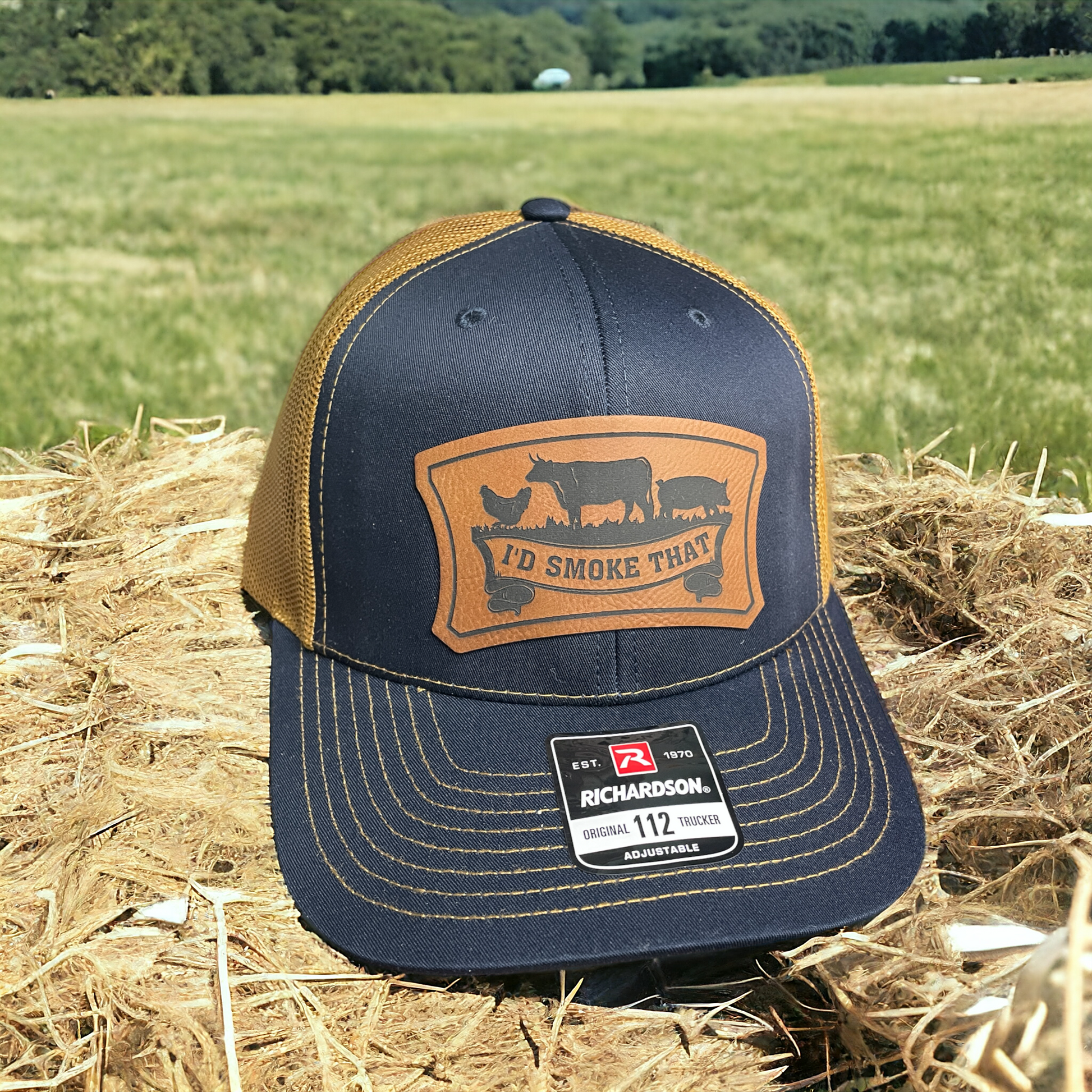 Navy trucker hat with tan mesh back, leatherette front logo patch, Richardson 112 label