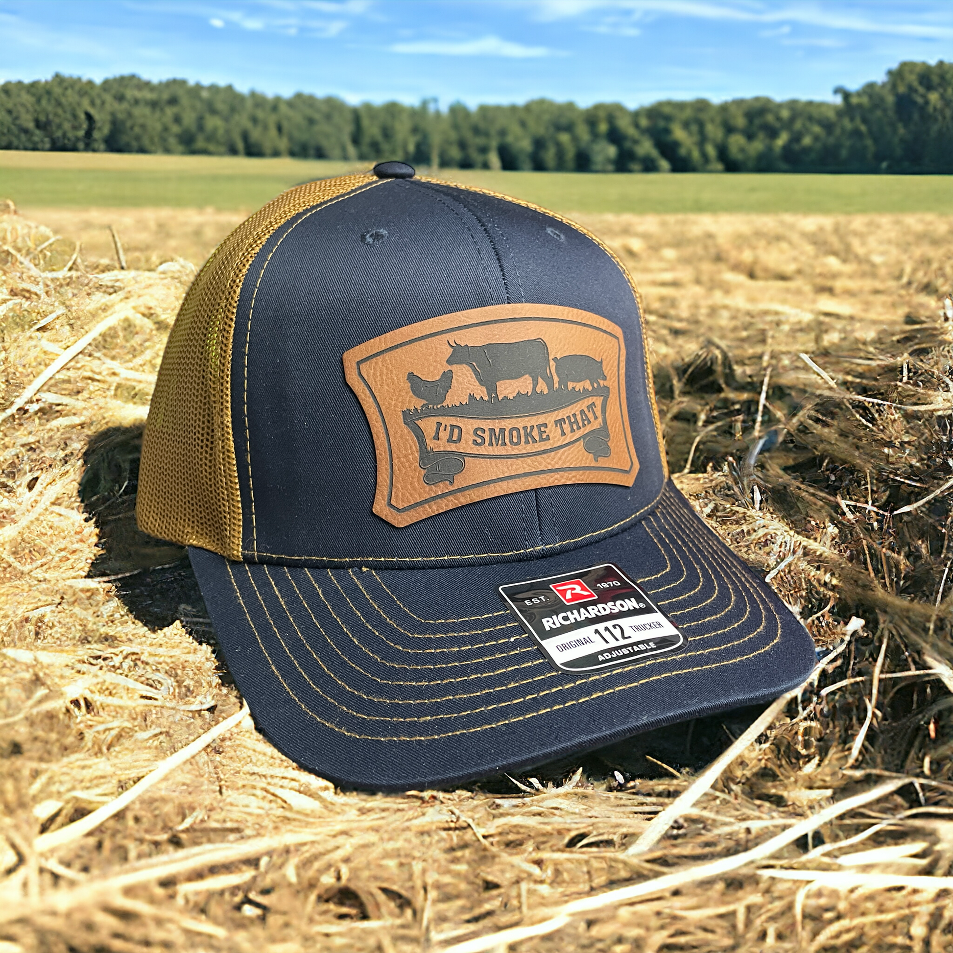 Navy trucker hat with tan mesh back, leatherette front logo patch, adjustable
