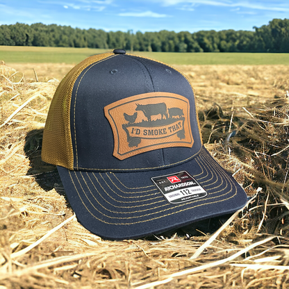 Navy trucker hat with tan mesh back, leatherette front logo patch, adjustable