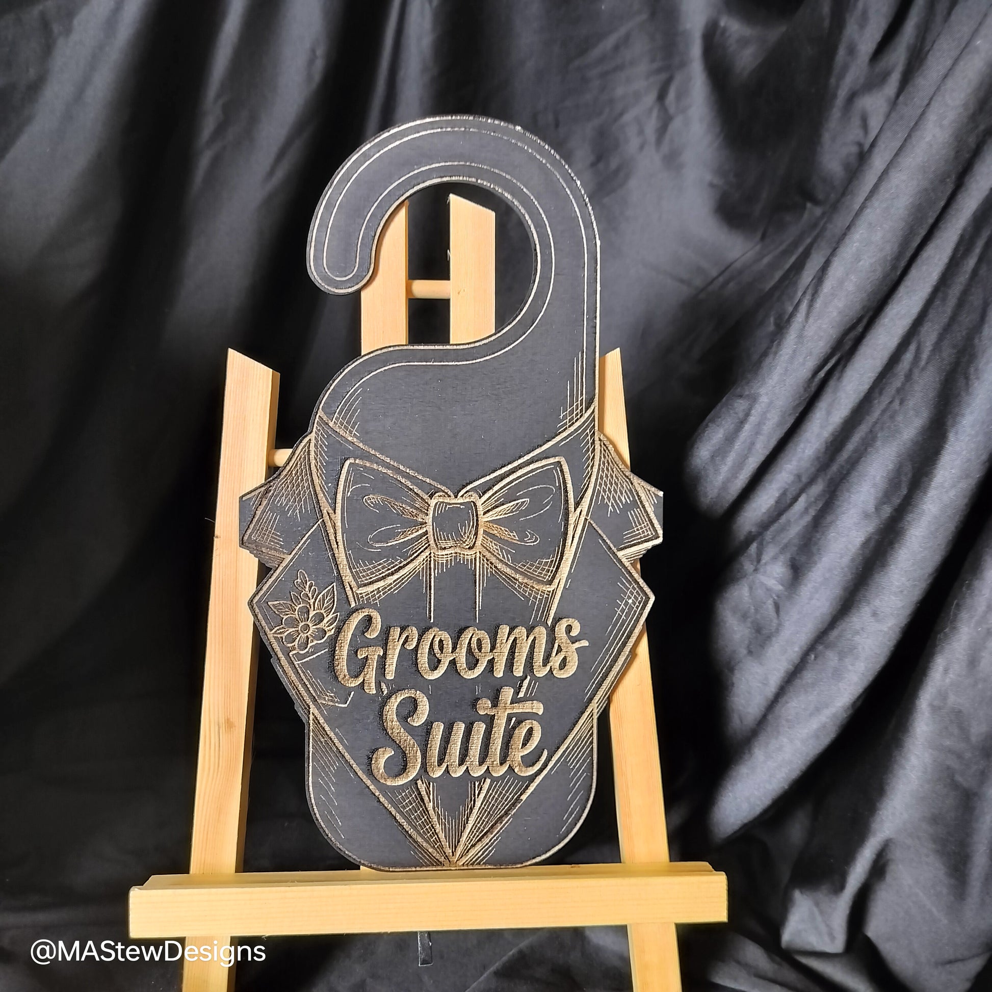 Laser-engraved wood door hanger with bow tie tuxedo design and 'Grooms Suite' text.