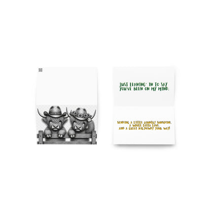 Opened greeting card showing grayscale cowboy cow illustration and poem text