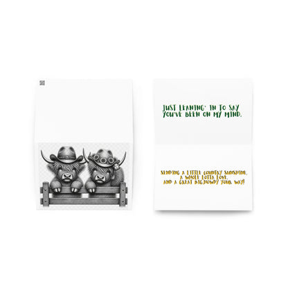 Opened greeting card with cowboy cow illustration and colored verse text