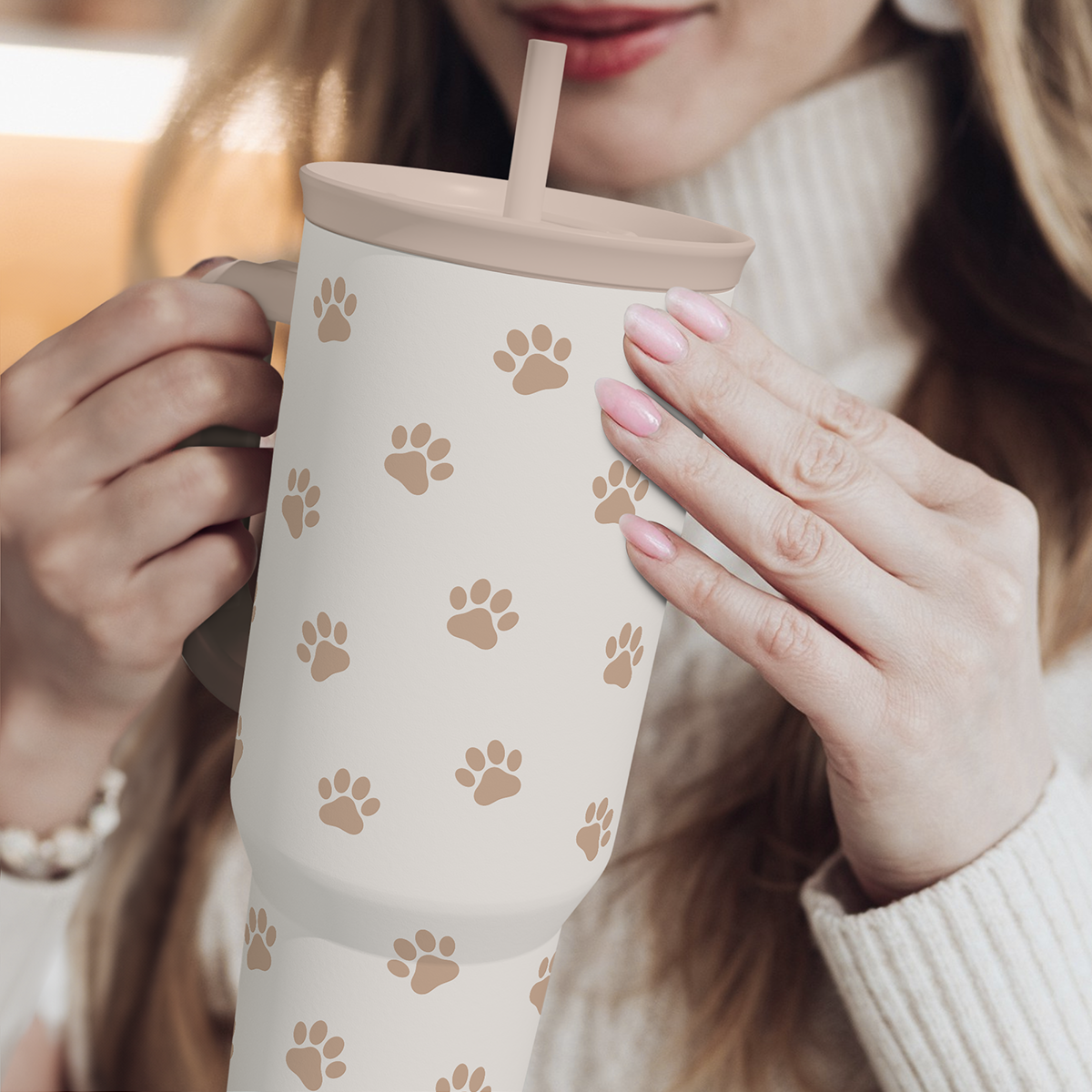 Brown Dog Slidemate 40oz tumbler held with handle and straw, tan paw print design