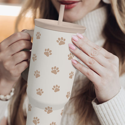 Brown Dog Slidemate 40oz tumbler held with handle and straw, tan paw print design