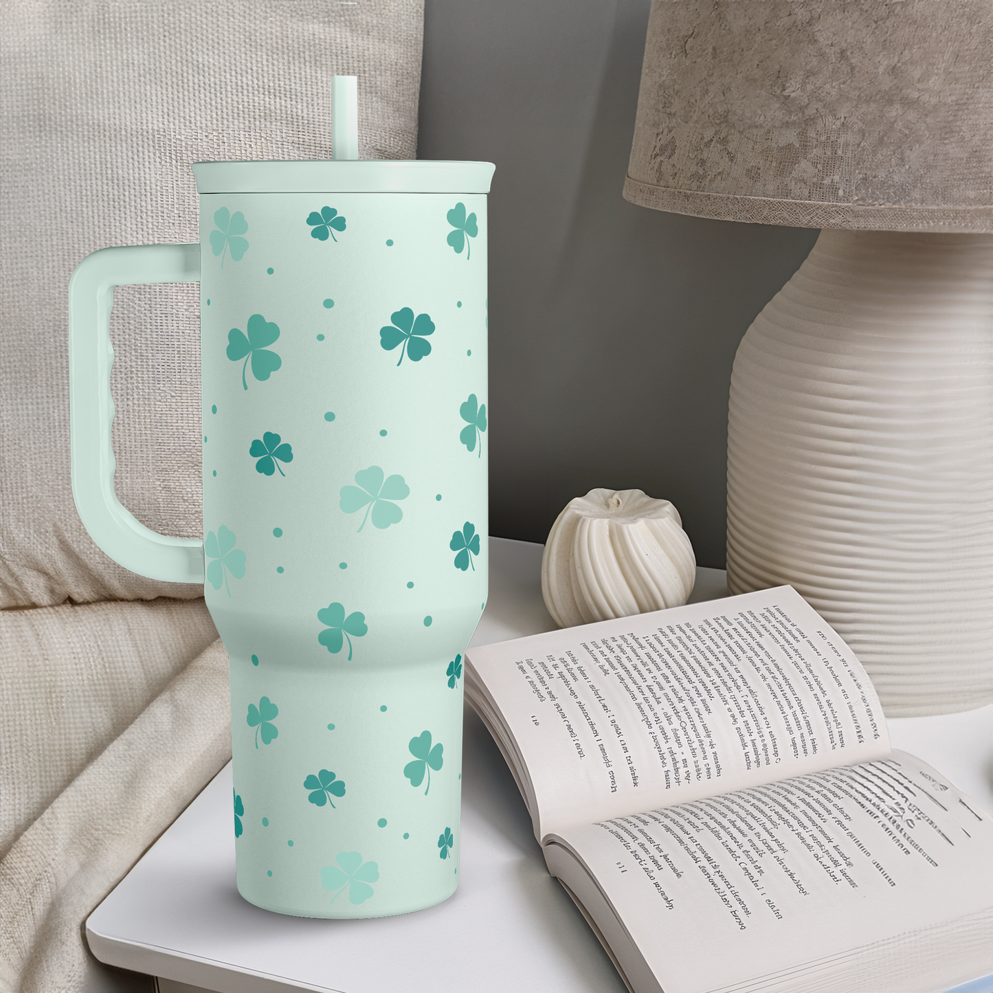 Mint green 40oz slide tumbler on table, shamrock clover pattern, straw lid