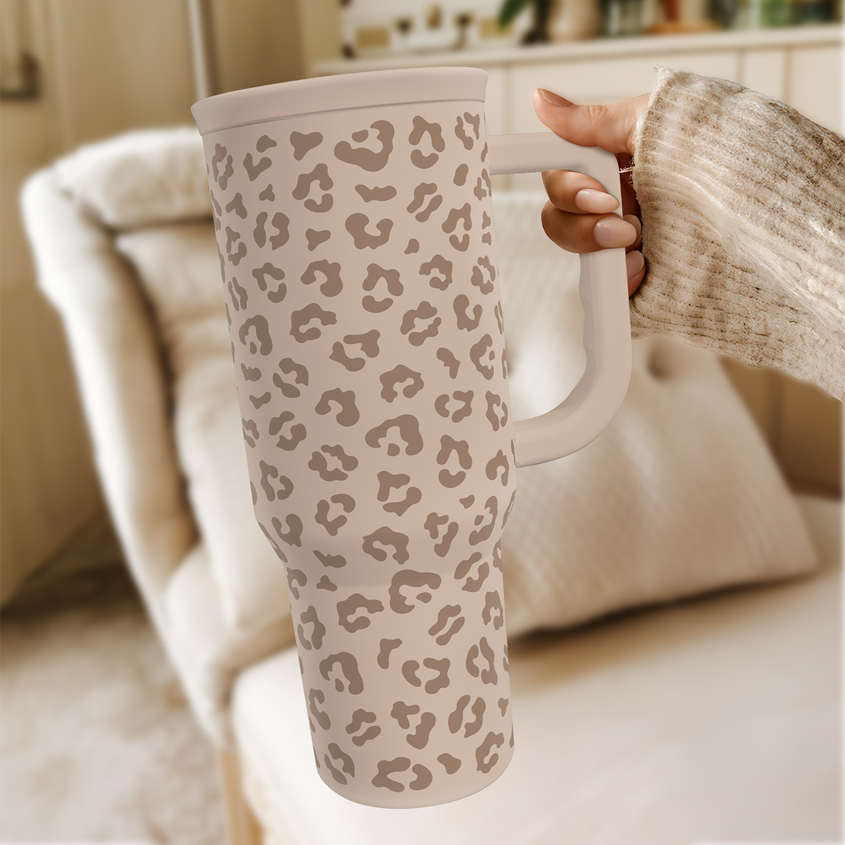 Leopard-print 40 oz tumbler with handle and straw, beige tan spots on couch