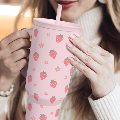 Pink strawberry-pattern 40oz tumbler held with straw