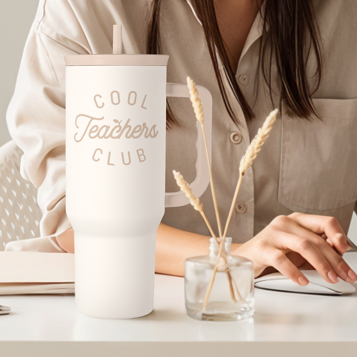 White 40oz tumbler with straw and “Cool Teachers Club” logo, on tabletop
