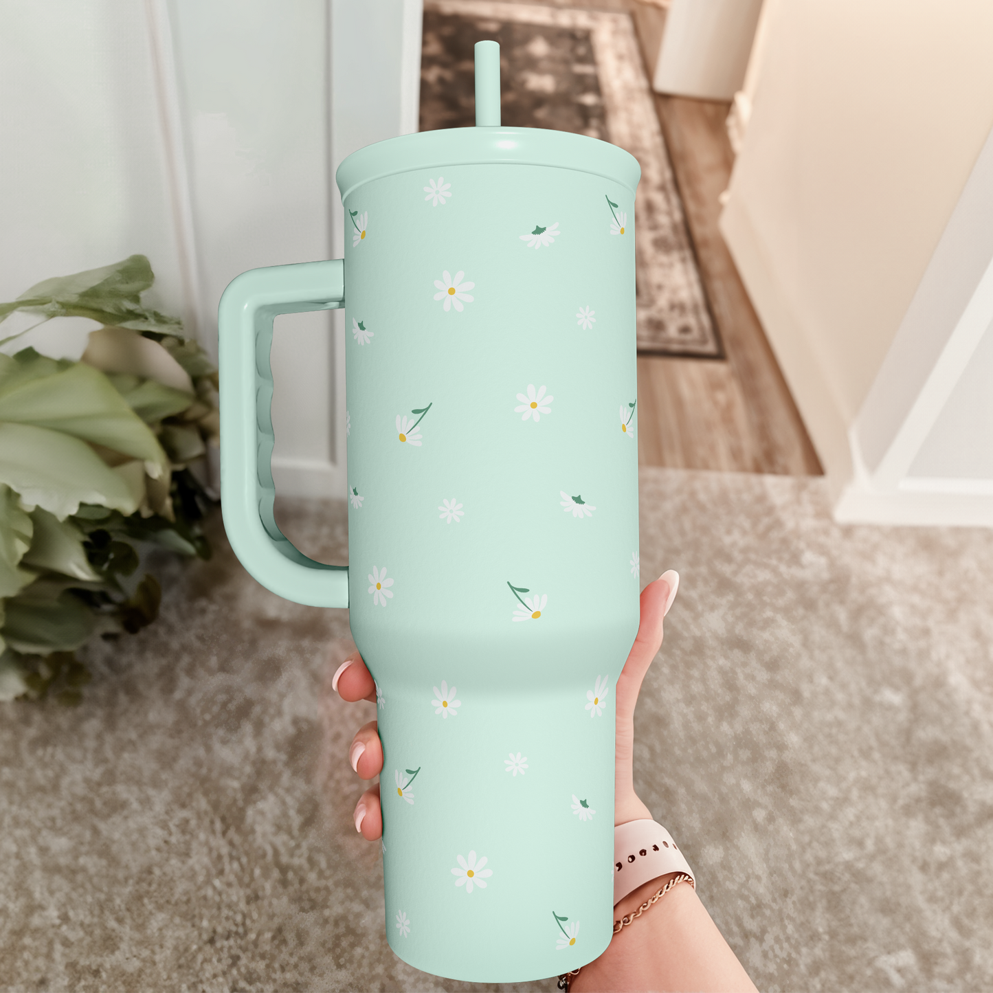 Mint daisy 40oz tumbler with handle, held upright with straw