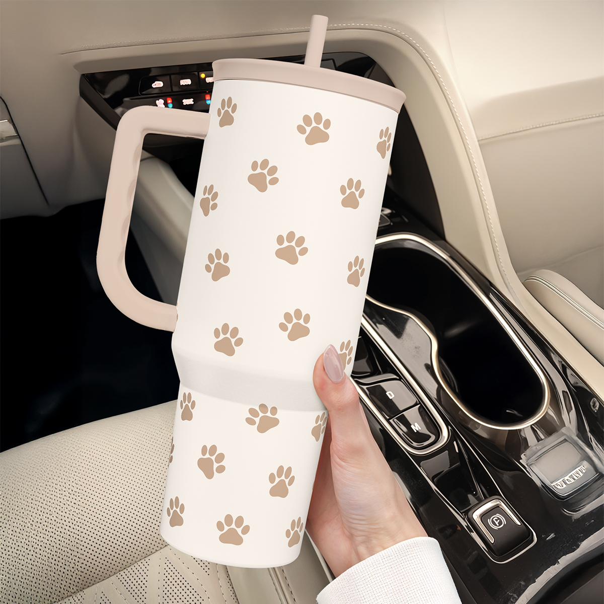 Brown Dog Slidemate tumbler with handle and straw, tan paw prints on white, in car seat