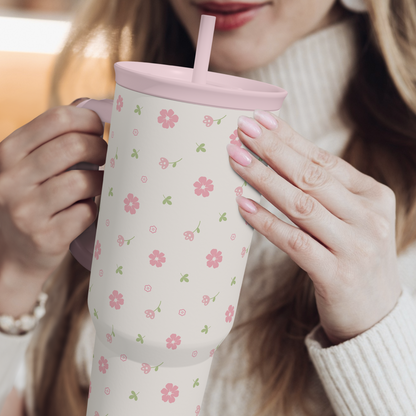 Pink floral 40oz tumbler with straw lid held in both hands