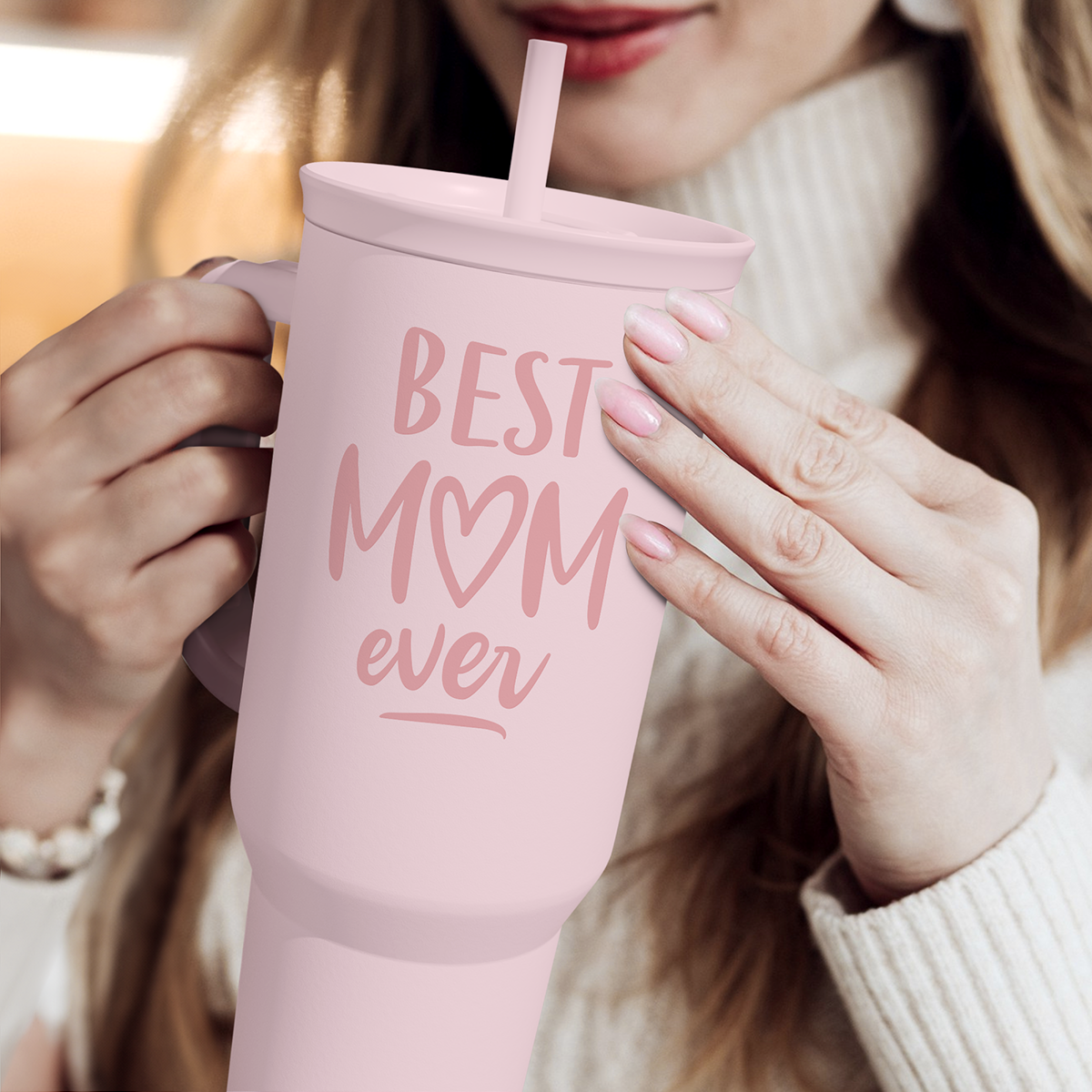 Pink 40oz tumbler with 'Best Mom ever' print and straw, held in hand