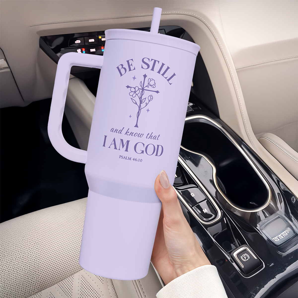 Lavender Christian tumbler with handle and straw, held for use in a car cup holder