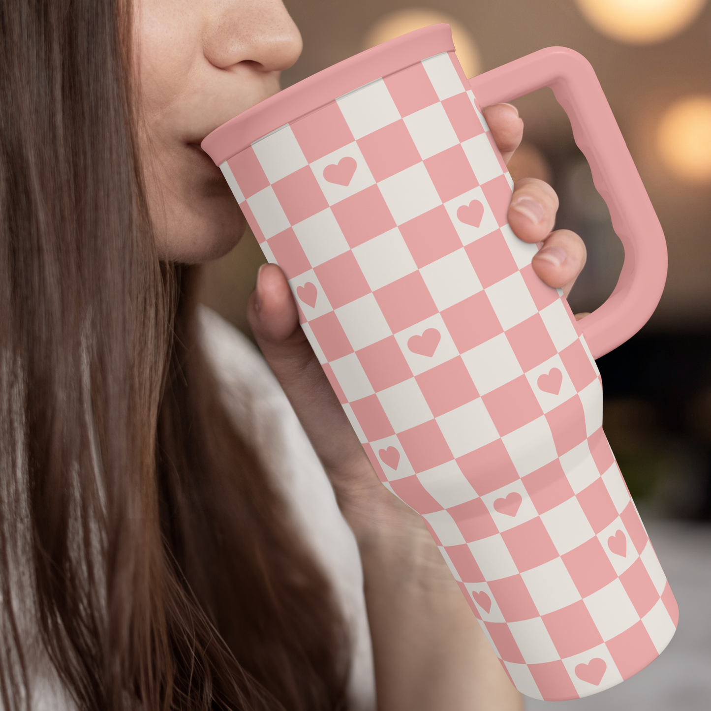 Coral checker heart 40oz tumbler with pink straw lid, sipped from by hand