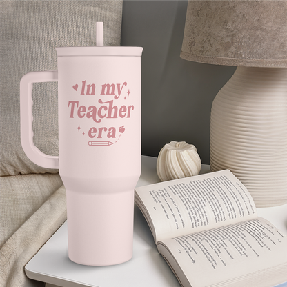Pink 40oz insulated tumbler with handle and straw on a tabletop