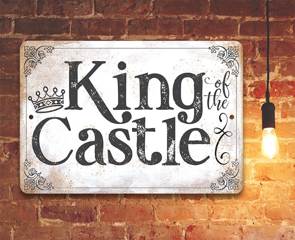 King of the Castle metal sign with crown, black lettering, and ornate corner flourishes