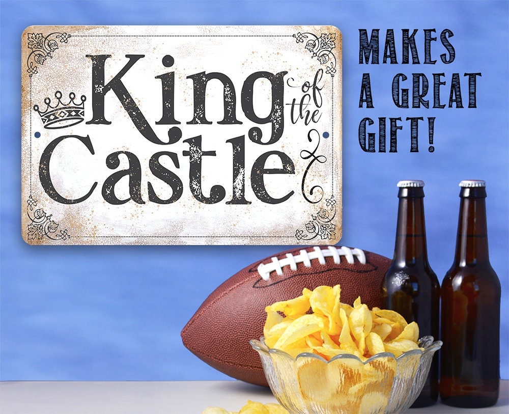 King of the Castle metal sign with crown, distressed border, and black lettering