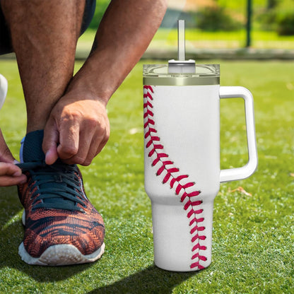 White insulated 40oz tumbler with handle and red baseball-stitched wrap, outdoors