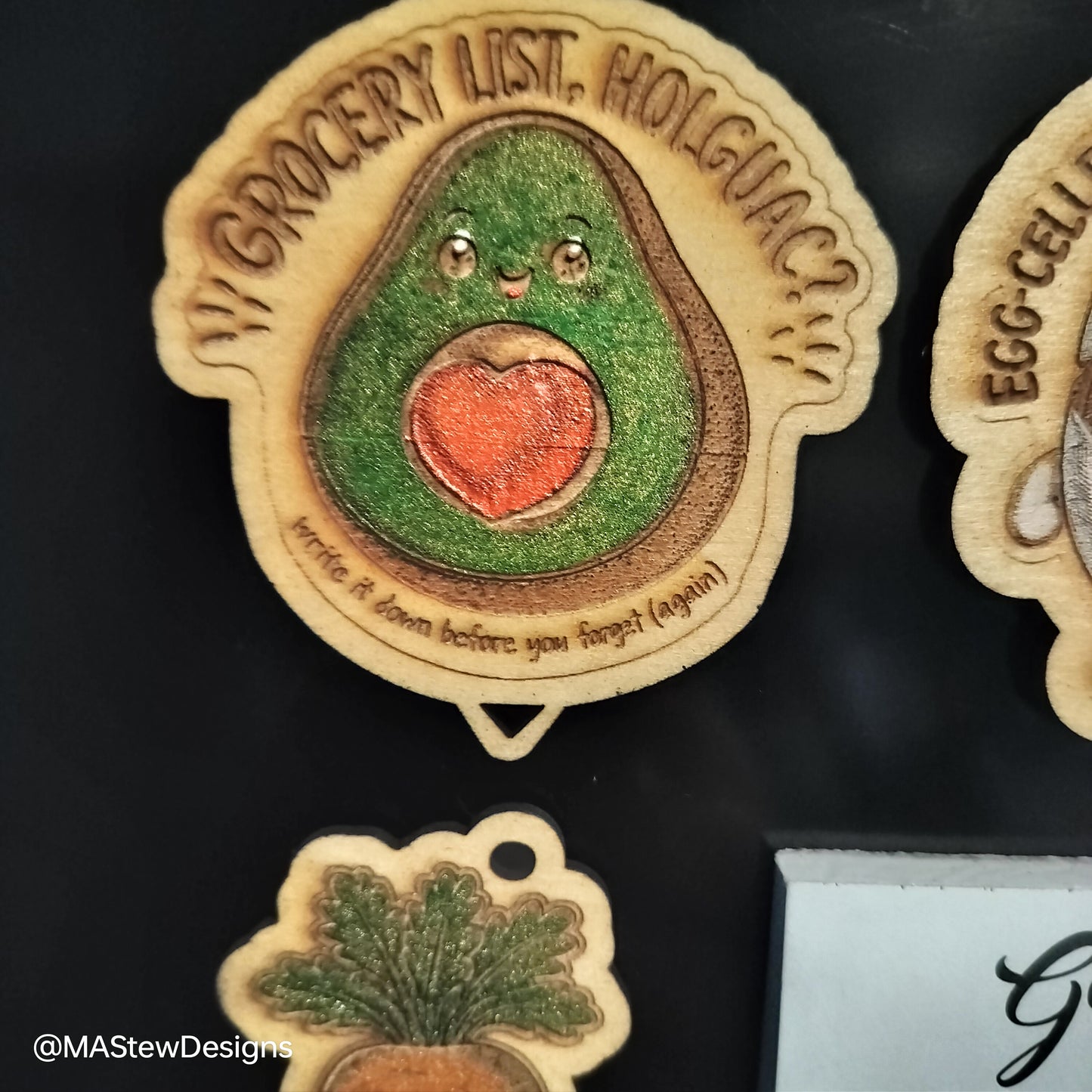 Avocado-themed magnetic pen keeper magnet with smiling face on dark fridge
