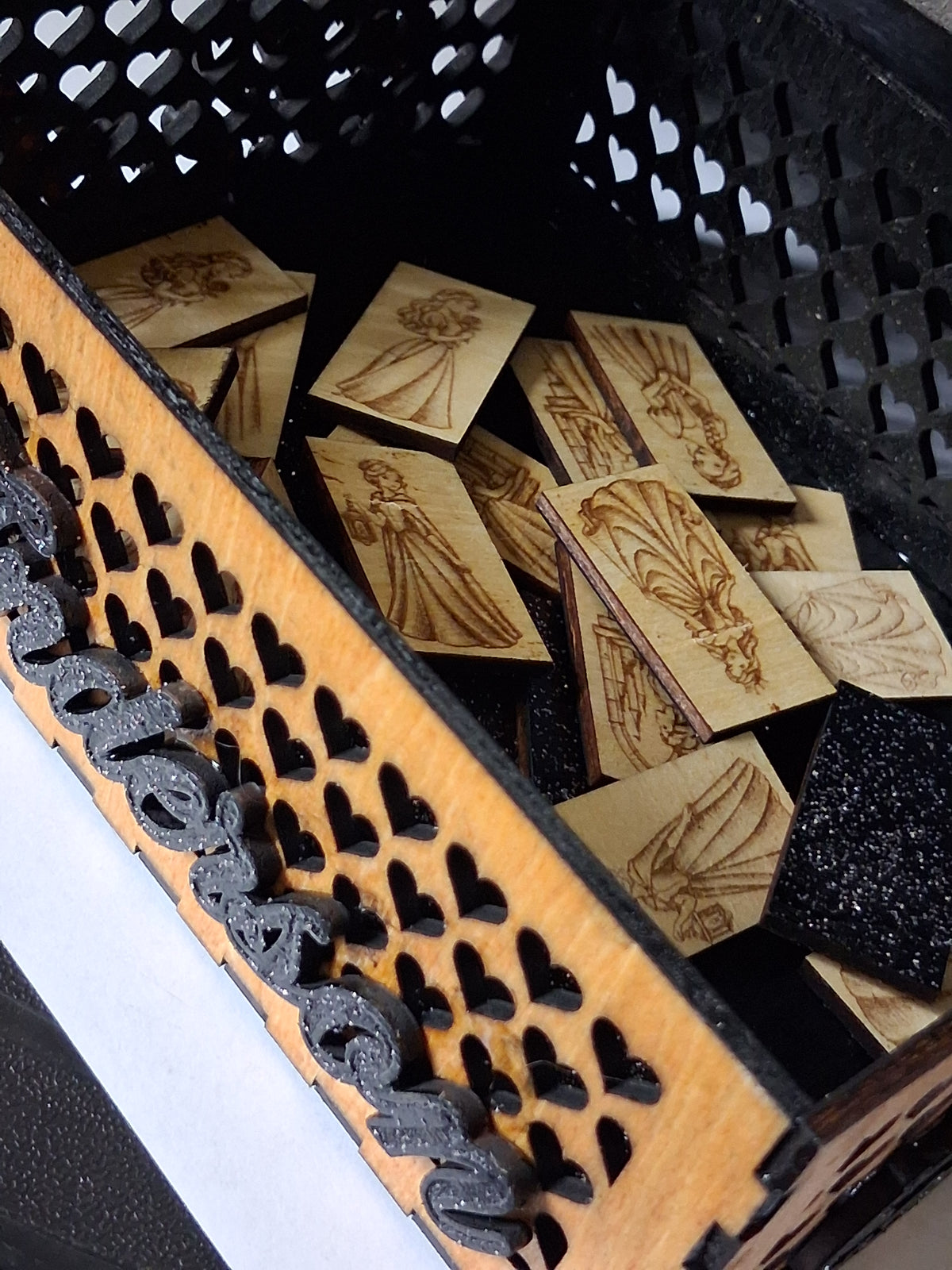 Close-up of wooden memory cards inside keepsake box with heart-pattern border strip