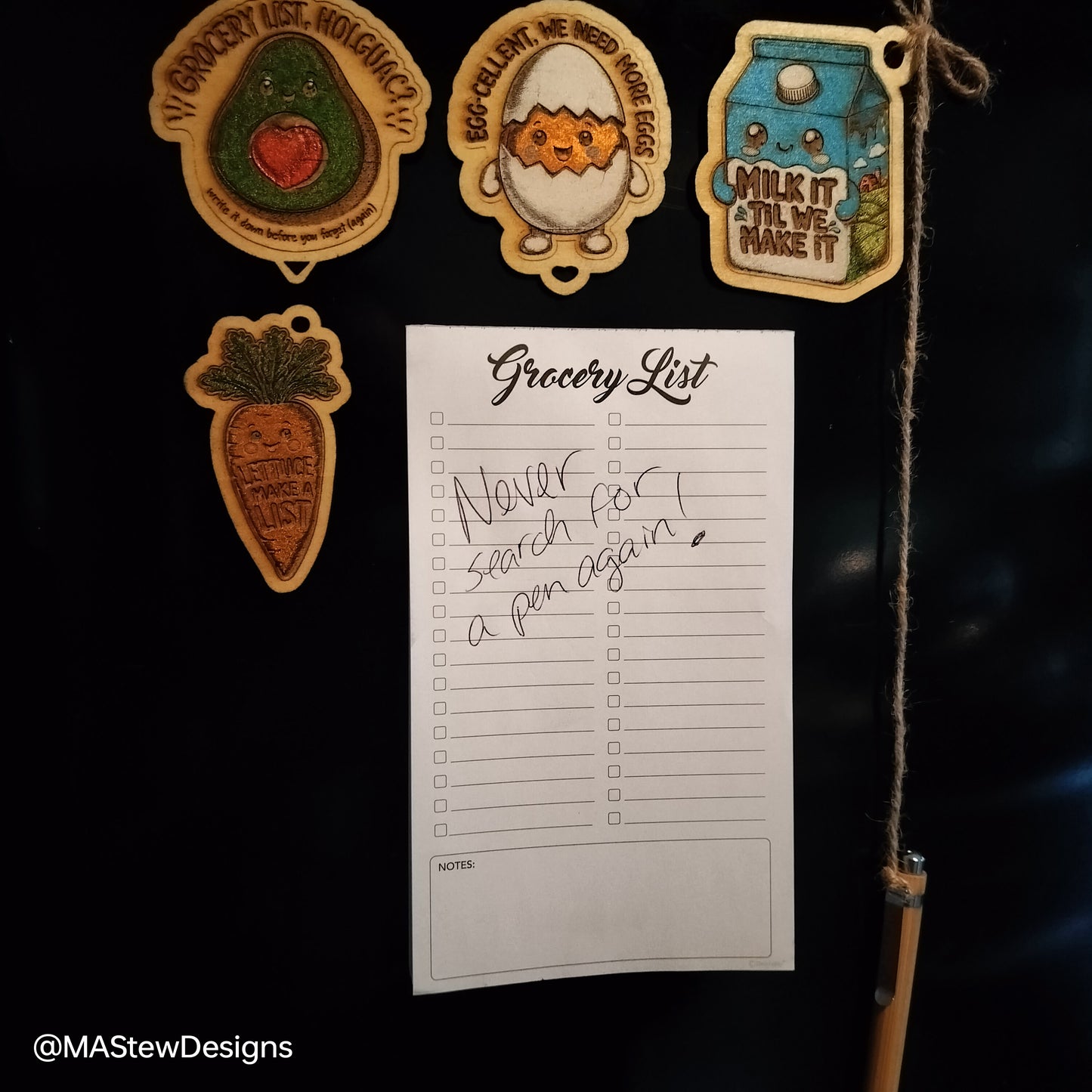 Magnetic pen keeper on fridge with grocery list paper and attached magnets
