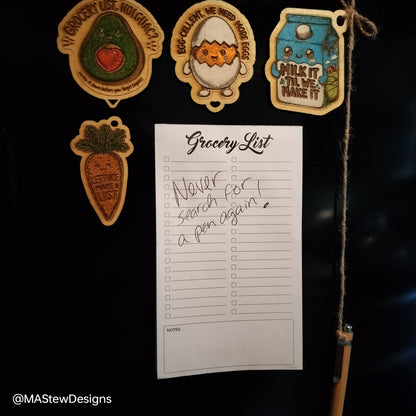 Magnetic pen keeper on fridge with grocery list paper and attached magnets