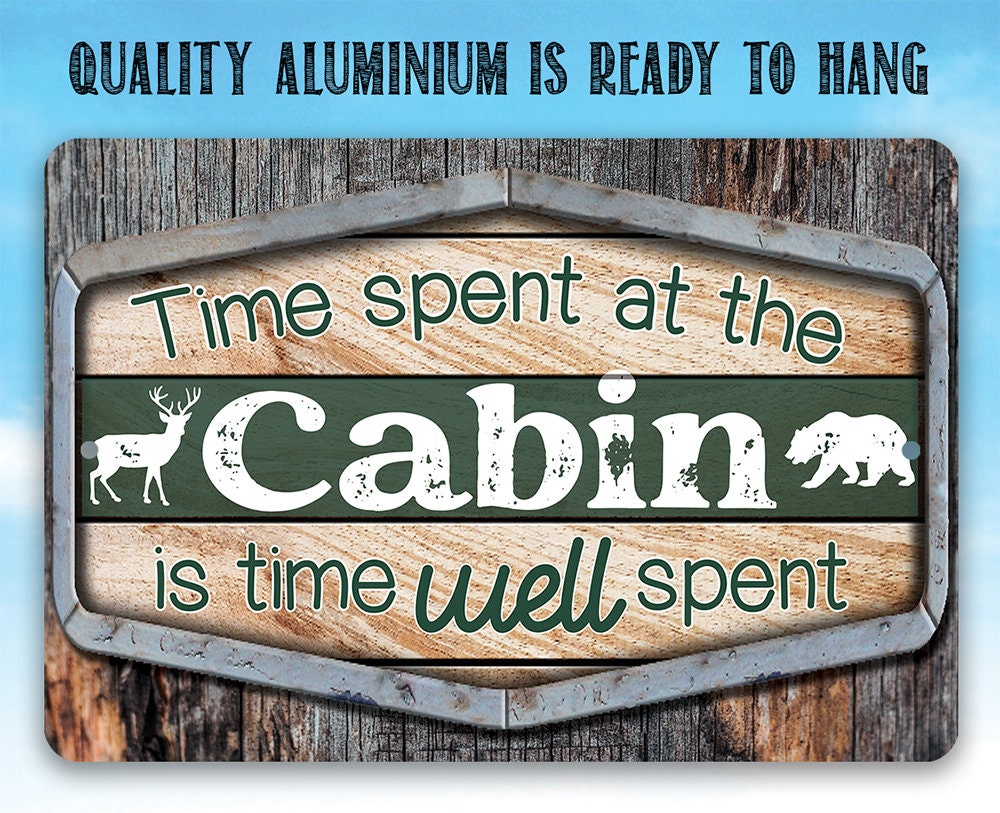 Cabin metal sign with green background, teal “Cabin” text, deer and bear silhouettes