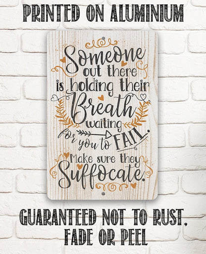Metal sign showing 'Someone out there is holding their Breath' with leaf and heart accents