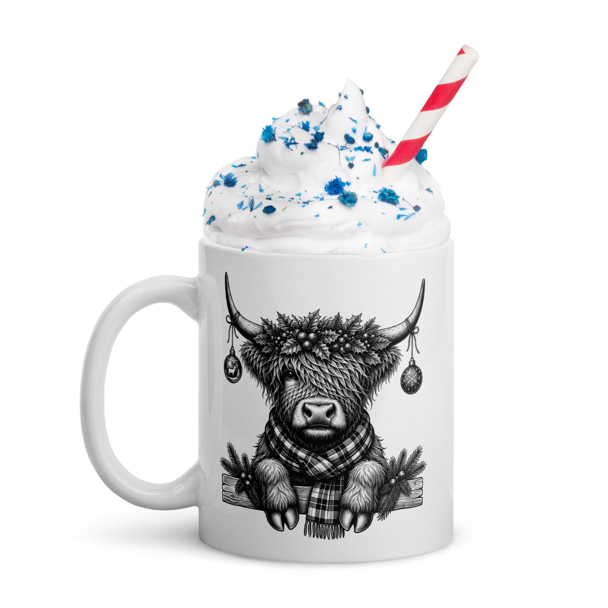 White mug with black highland cow graphic, blue-tinted whipped cream, striped straw