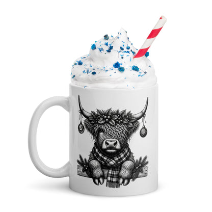 White mug with black highland cow graphic, blue-tinted whipped cream, striped straw
