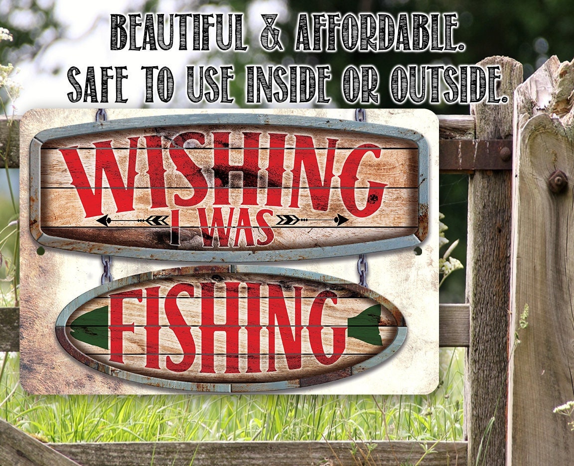 Outdoor metal fishing sign on a fence with red "Wishing I was" and "Fishing"